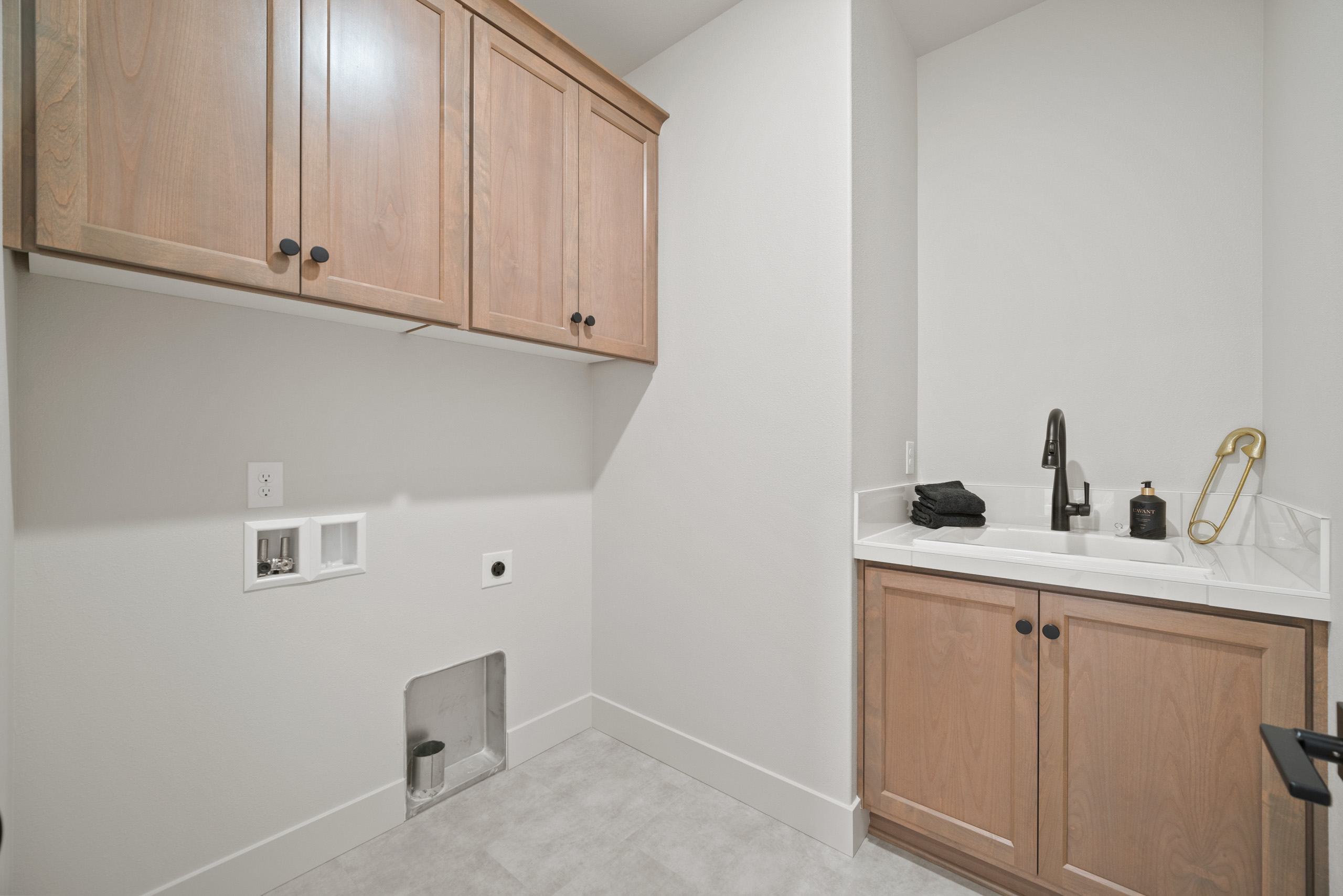 Modern laundry room with washer, dryer, and cabinetry.