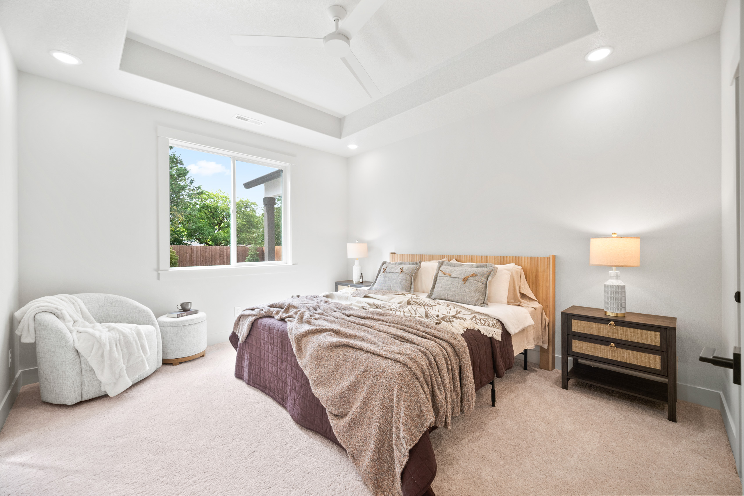 Bright bedroom with large window, cozy bed, and modern decor.