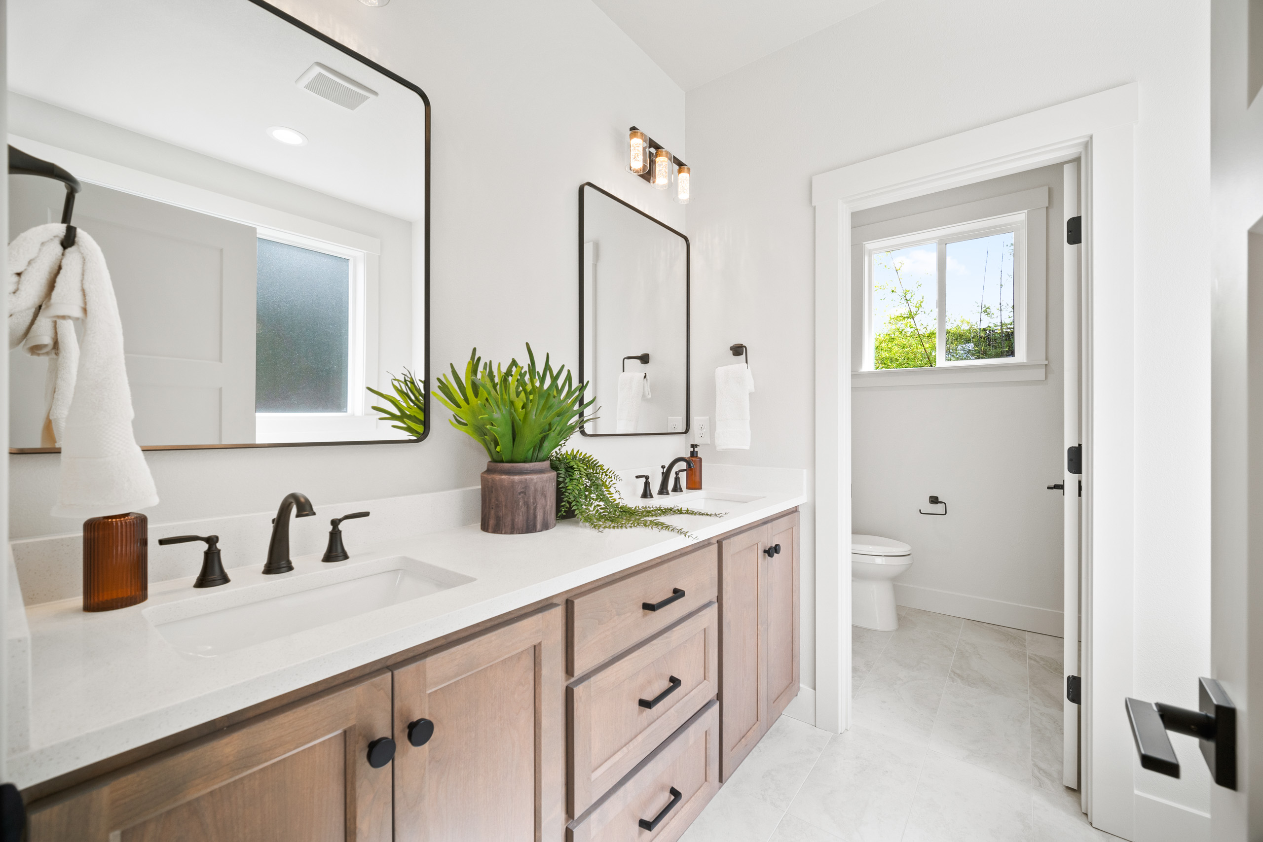 Bright bathroom with double sink and large mirror.