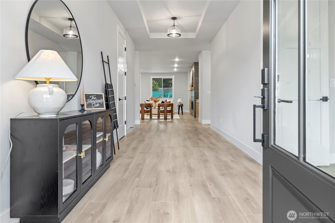Bright modern hallway with wooden floors and glass door.
