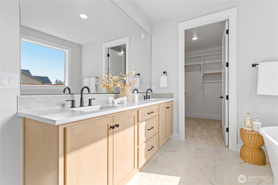 Bright modern bathroom with double sinks and a walk-in shower.