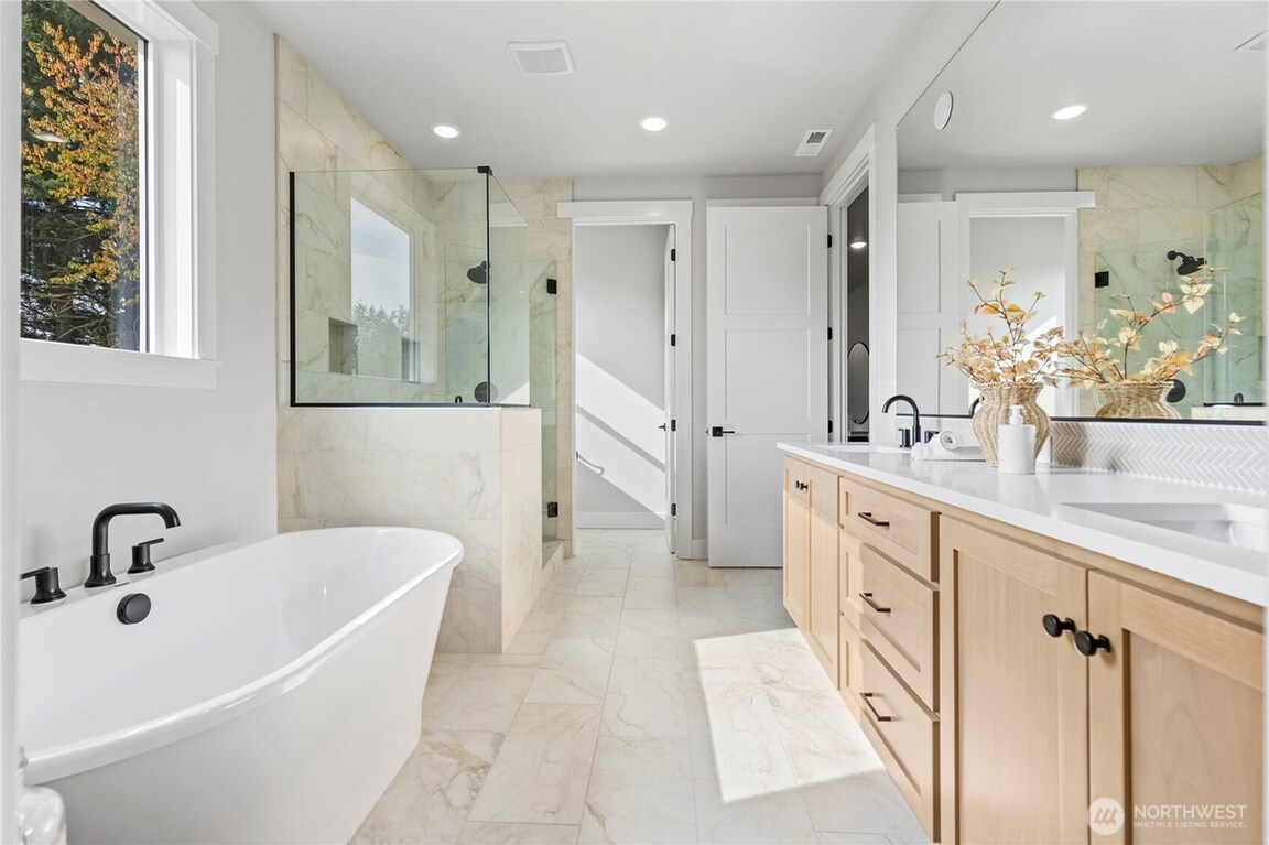 Modern bathroom with large bathtub and double vanity.