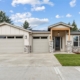 Modern single-story house with a two-car garage and front lawn.