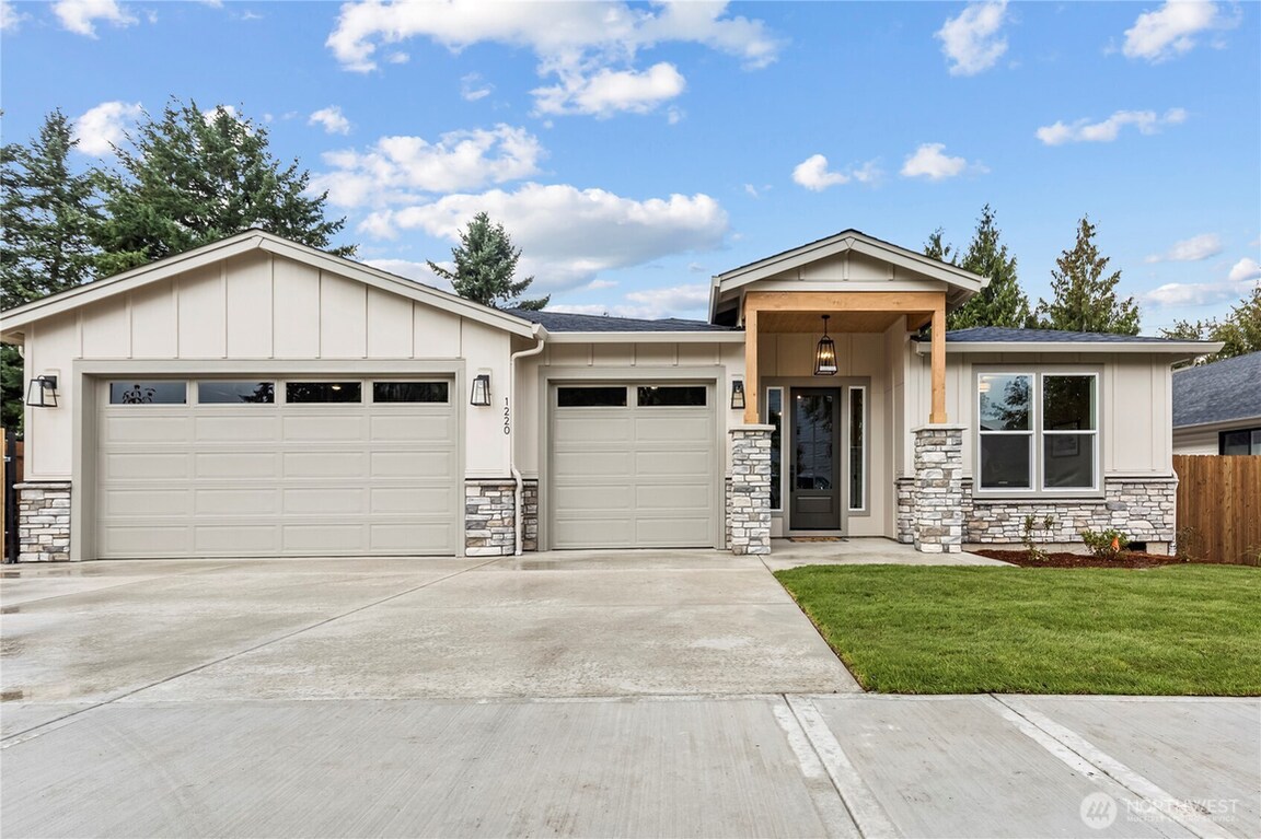Modern single-story house with a two-car garage and front lawn.
