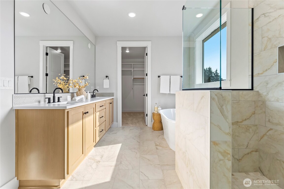 Modern bathroom with dual sinks and large windows.