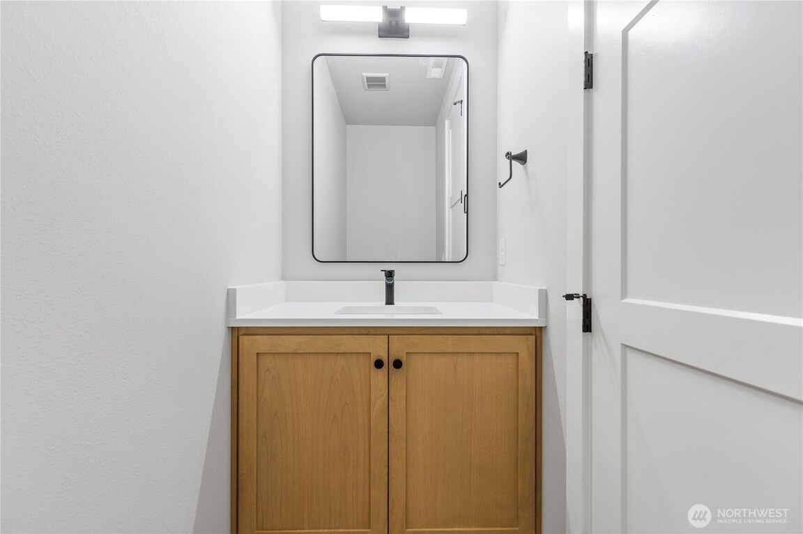 Minimalist bathroom vanity with wooden cabinet and white sink.