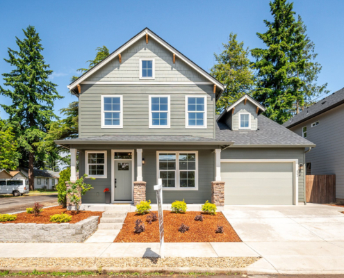 A modern two-story house with a well-kept front yard and garage.