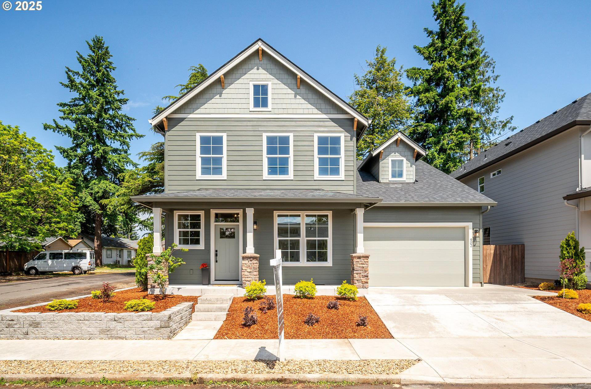 A modern two-story house with a well-kept front yard and garage.