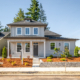 Modern two-story house with a well-maintained front yard and clear blue sky.
