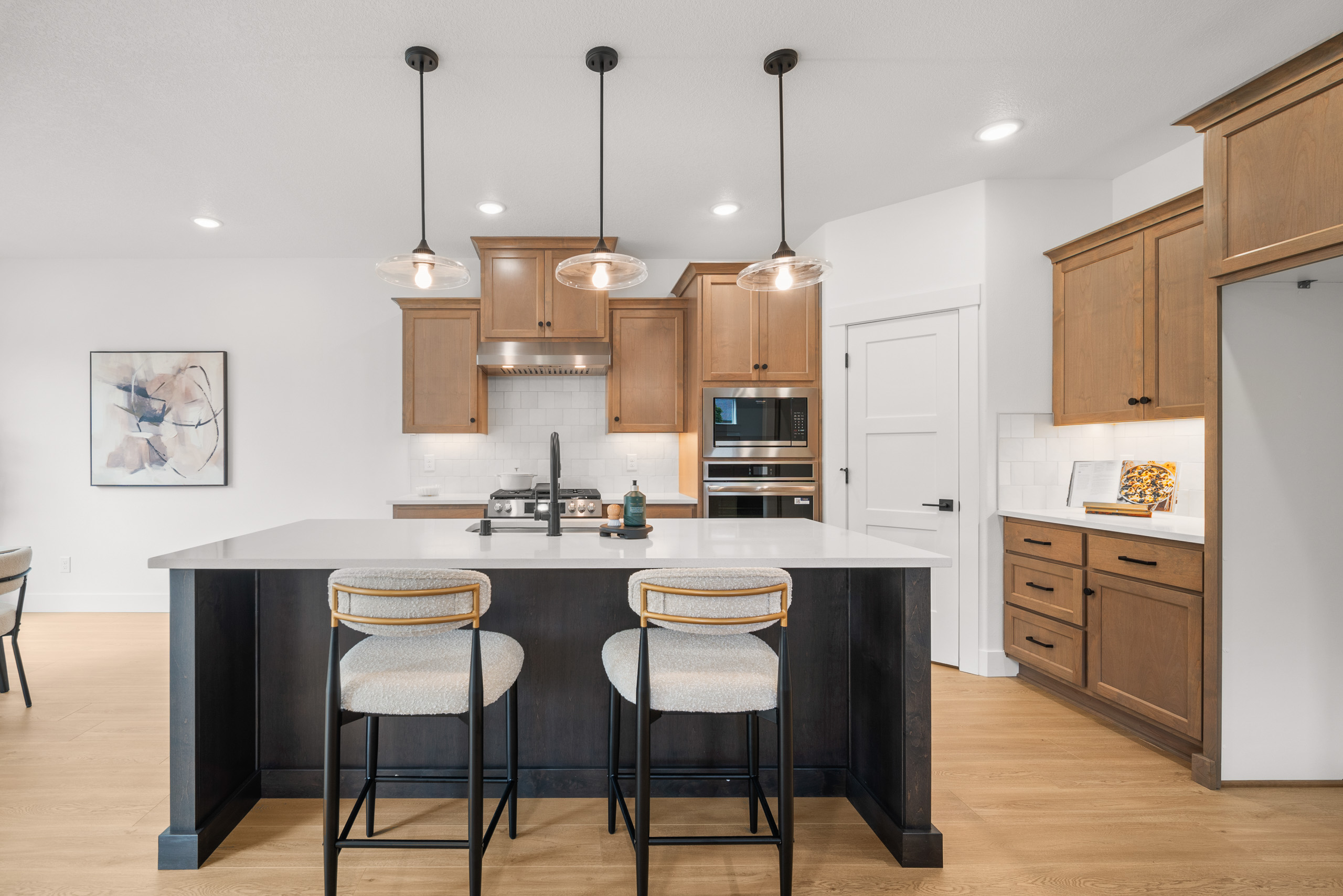Modern kitchen with white countertops and wooden cabinets.