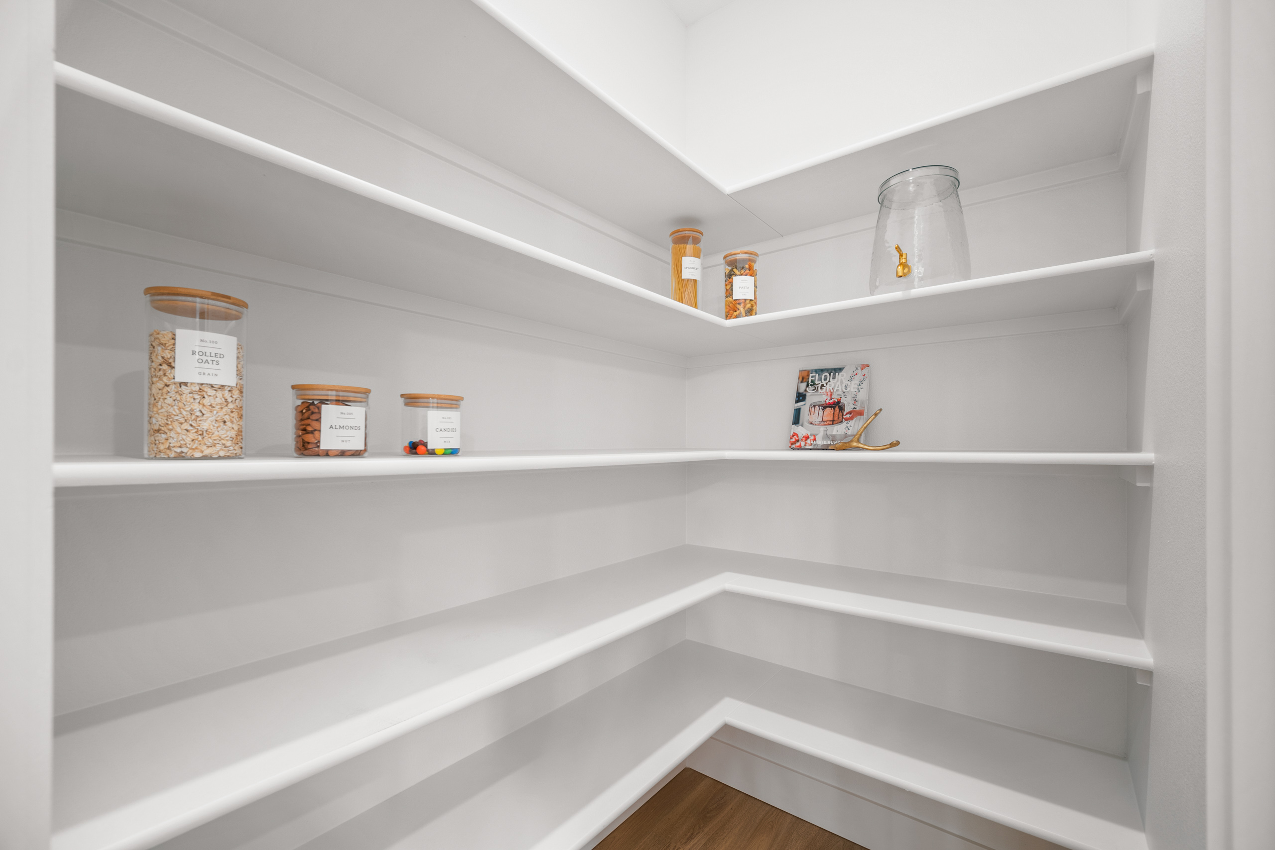 Bright, spacious pantry with clean white shelves and organized storage.