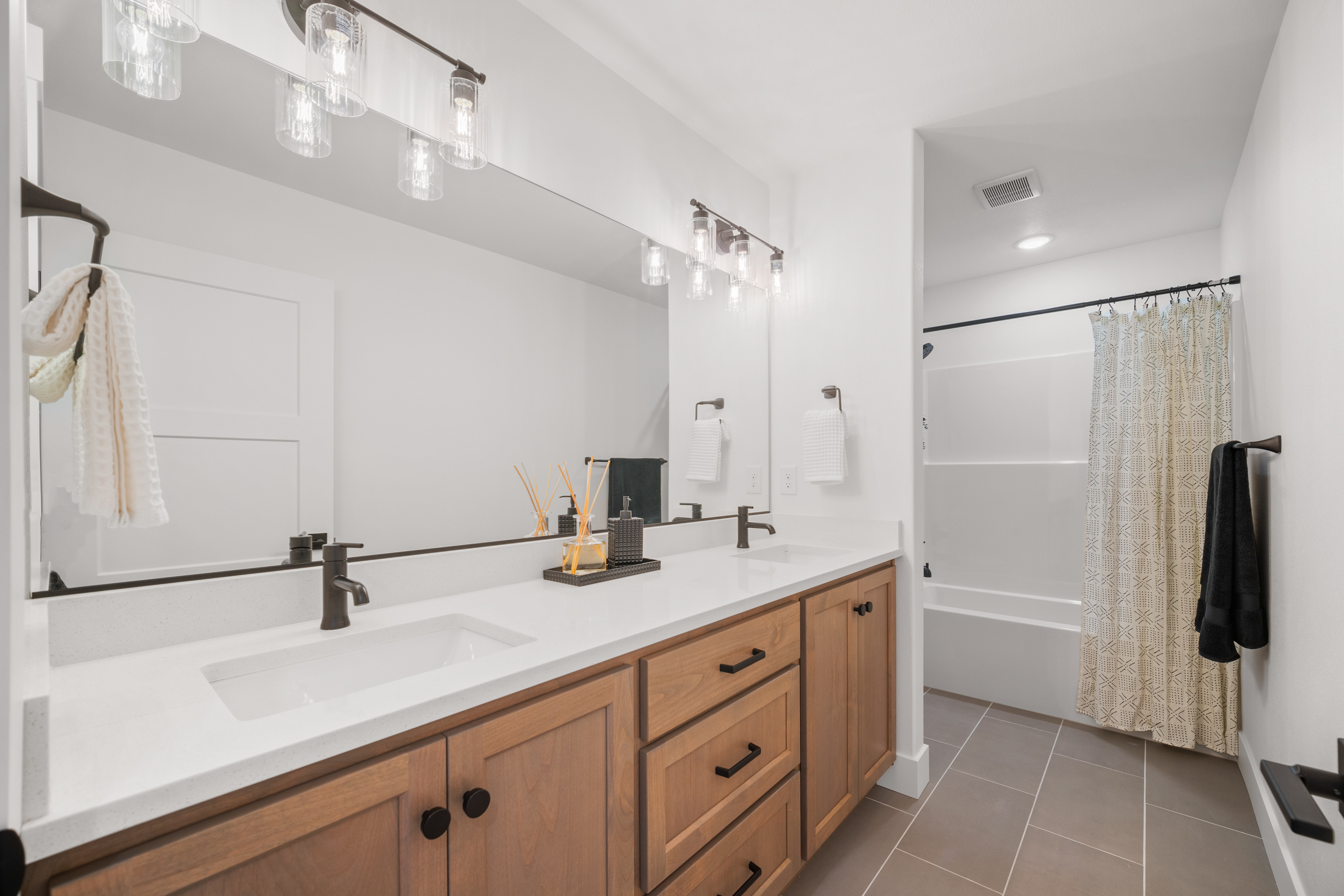 Modern bathroom with double sinks and wooden cabinetry.