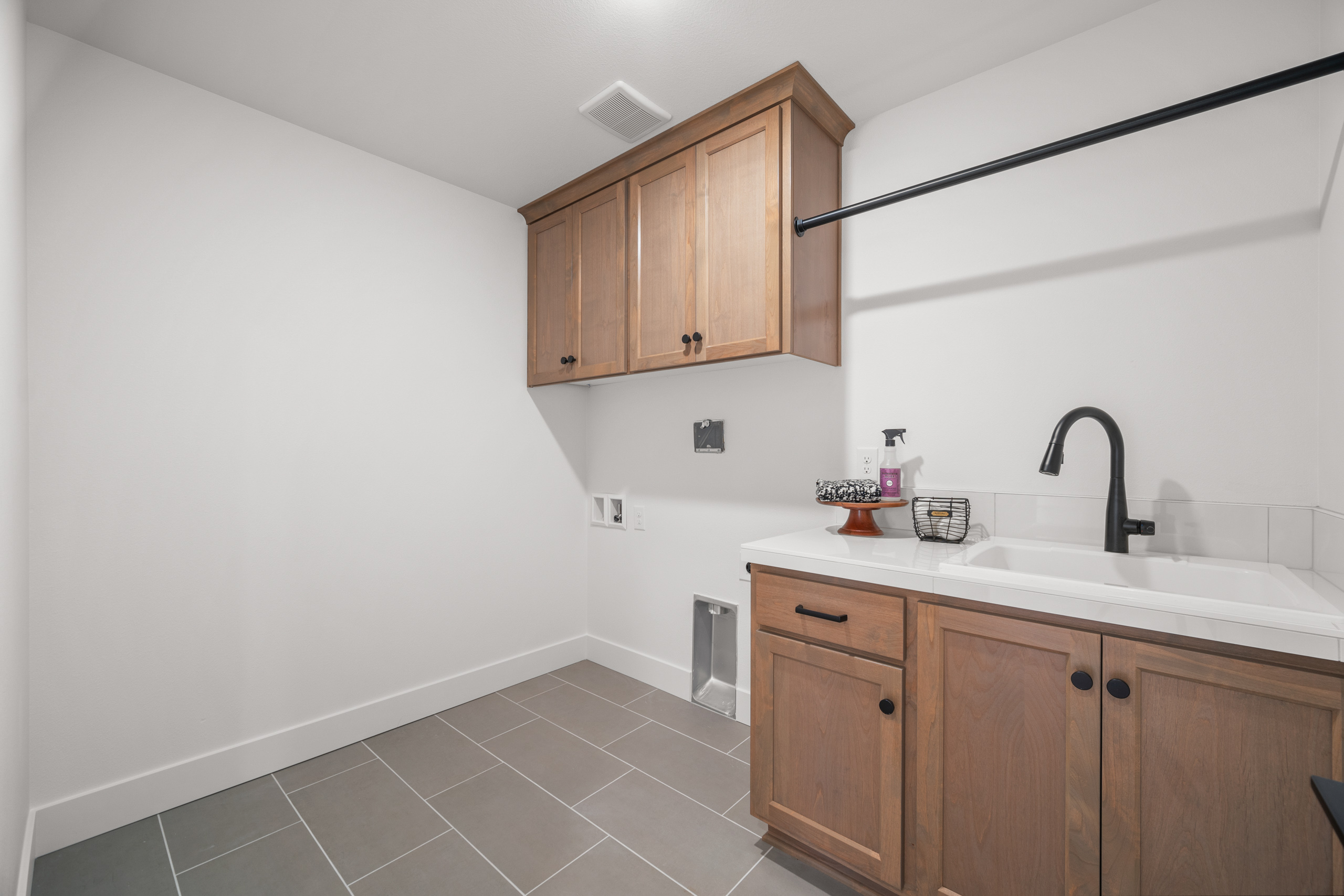 Modern kitchen with wooden cabinets and tiled floor.