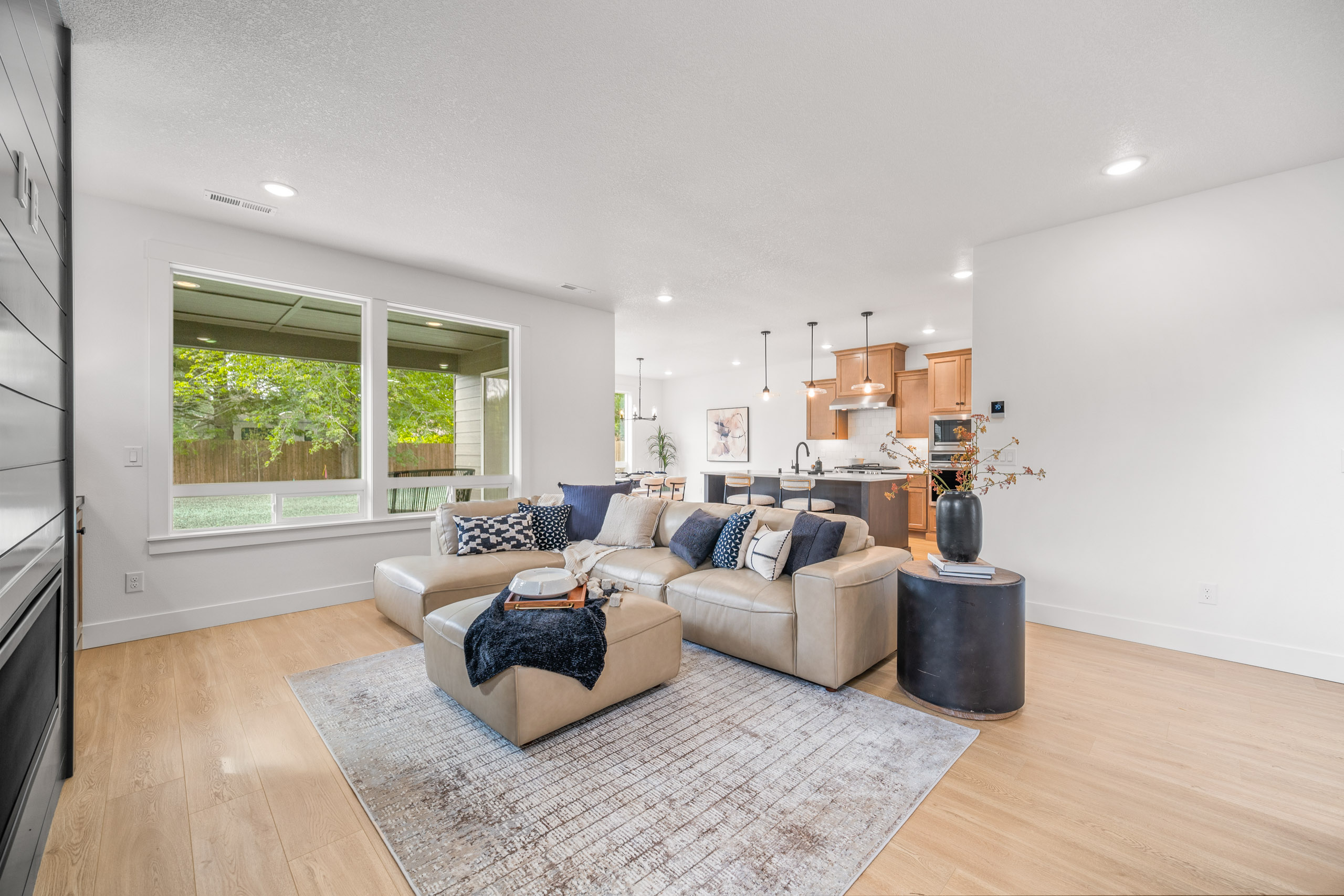 Modern living room with neutral tones and large windows.