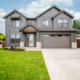Modern two-story house with a manicured lawn and attached garage.