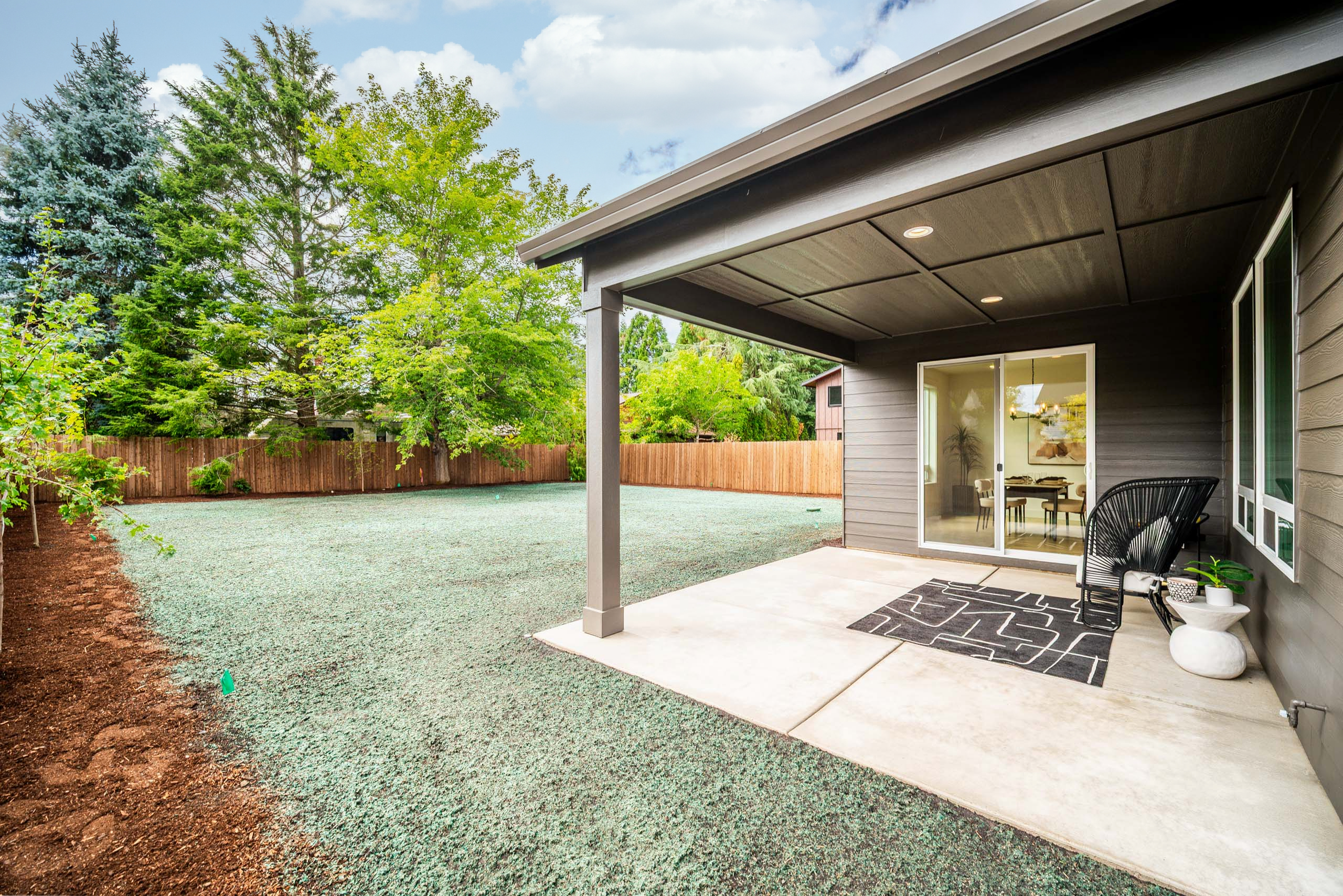 Modern backyard patio with gravel landscaping and covered seating area.