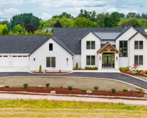 Modern white houses with clean landscaping under a cloudy sky.