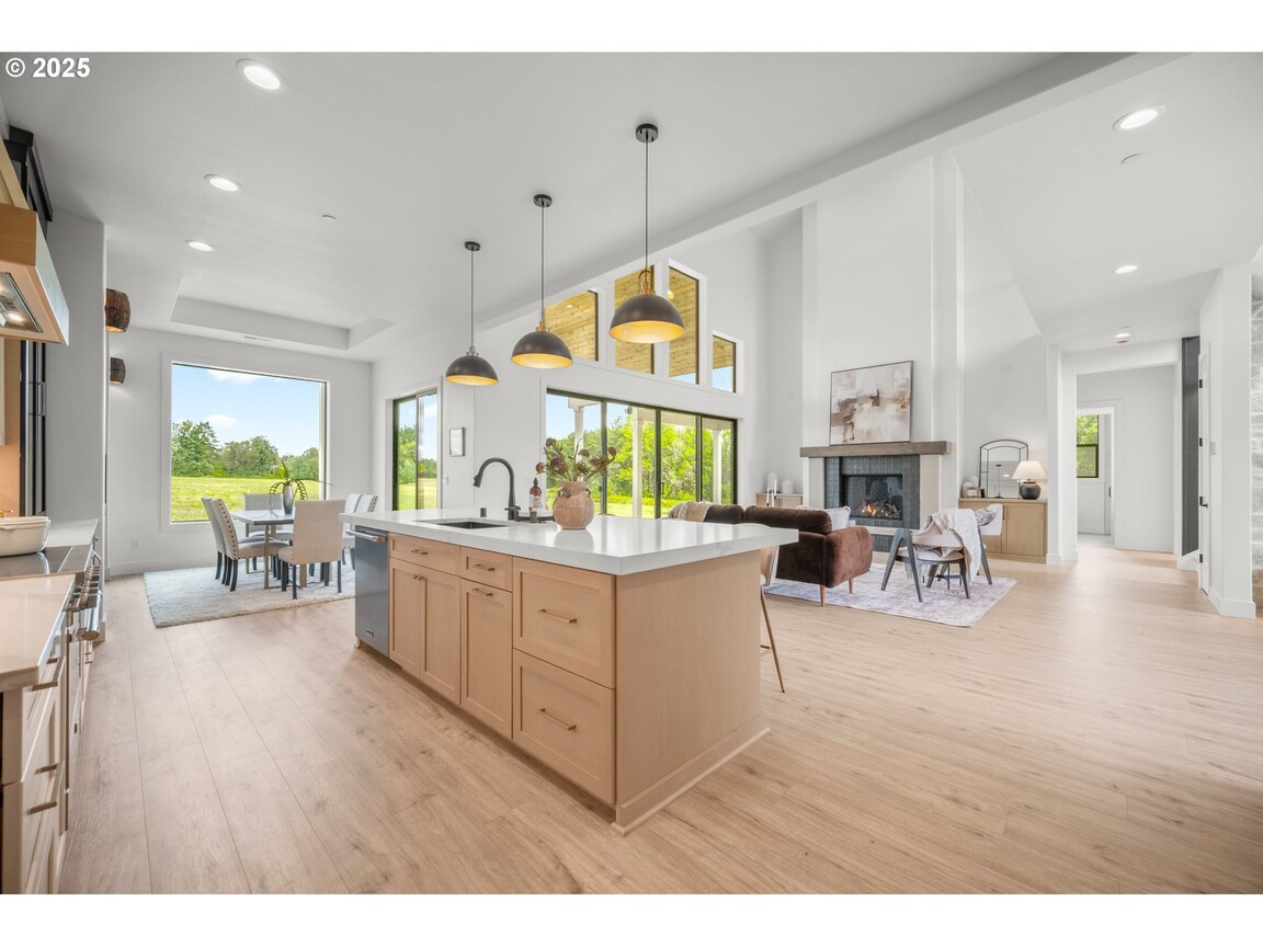 Modern kitchen with wooden island and pendant lights.