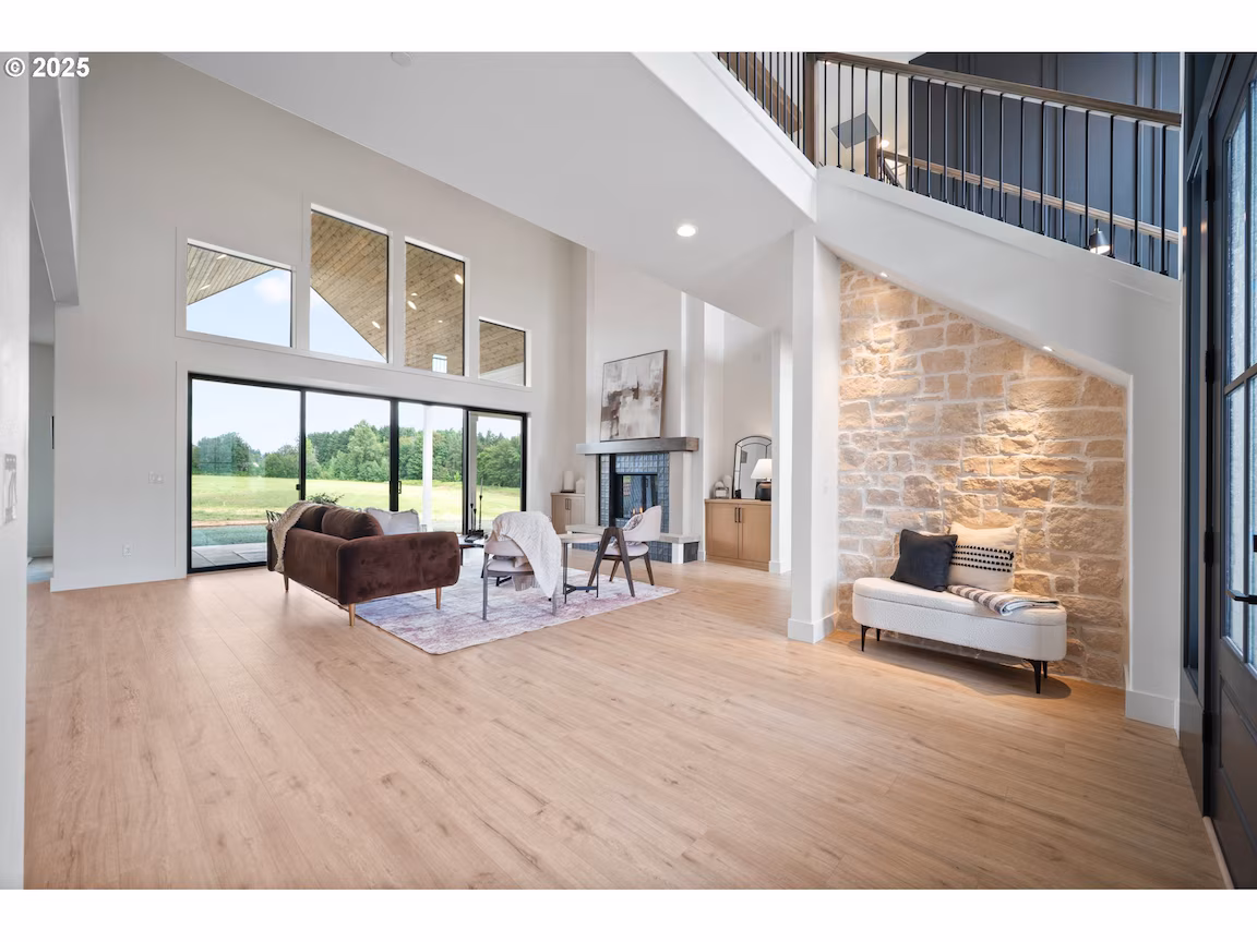 Bright, modern living room with large windows and wooden flooring.