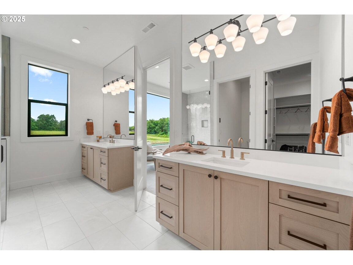 Modern bathroom with dual sinks and large mirrors.