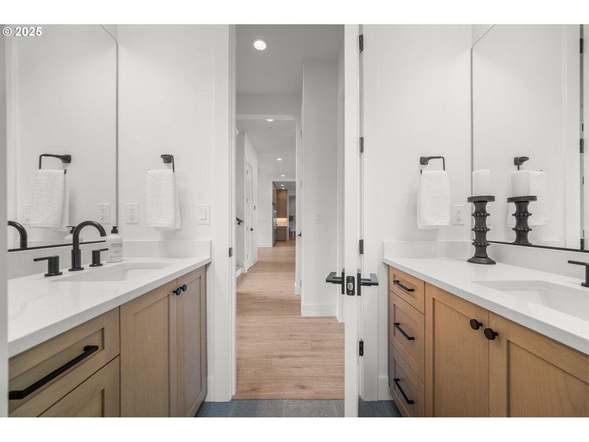 Modern bathroom with double sinks and large mirrors.