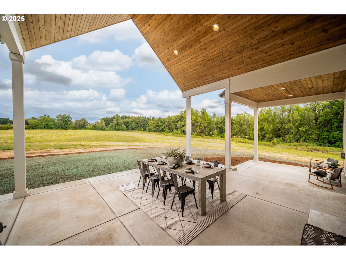 Covered outdoor dining area with a scenic countryside view.
