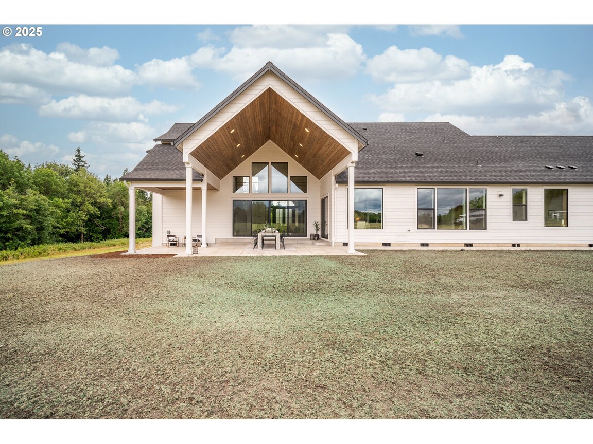 Modern single-story house with a spacious front porch and large windows.