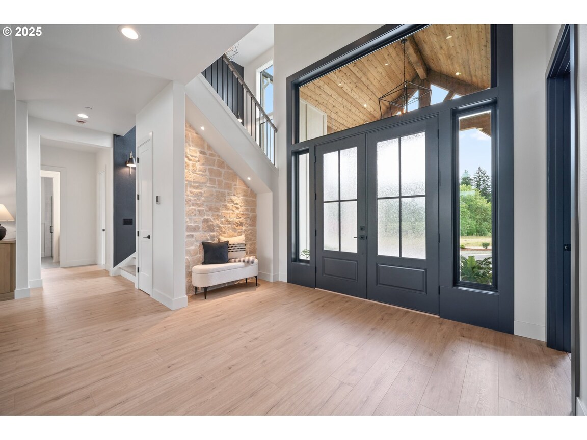 Modern living room with large windows and wooden ceiling.