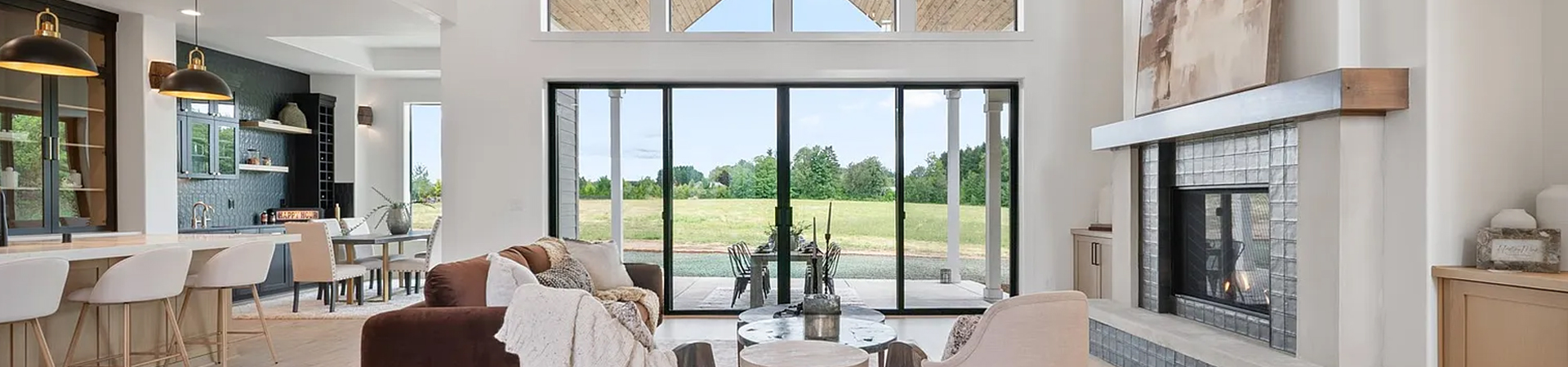 Modern kitchen with large windows overlooking a green outdoor space.