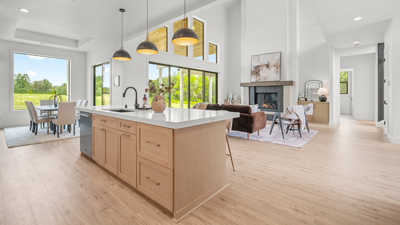 Modern kitchen with wooden island and pendant lights.