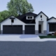 Modern dark gray and white two-story house with large garage and driveway.